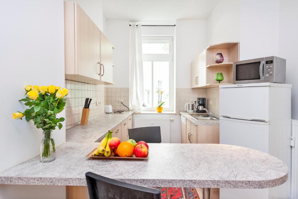 a kitchen with a table with a tray of fruit on it at Apartment Pette C40 in Berlin