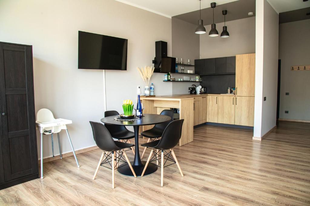 uma cozinha e sala de jantar com uma mesa preta e cadeiras em Closer to the Sea em Saulkrasti