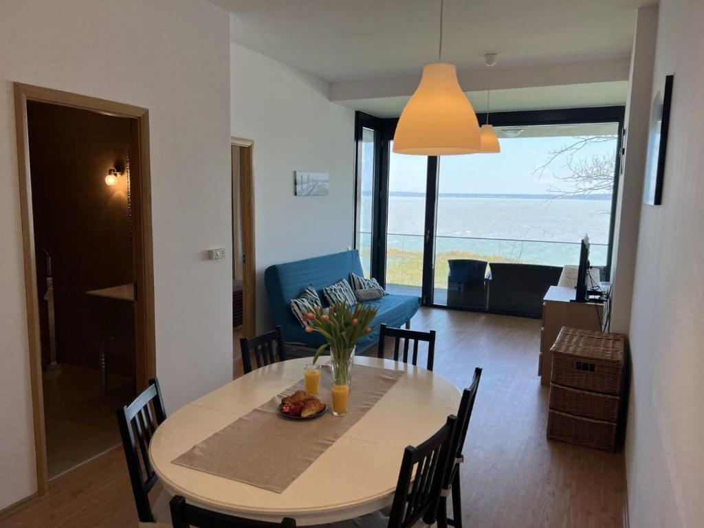 a dining room and living room with a table and chairs at AMP Apartman - Siófok in Siófok