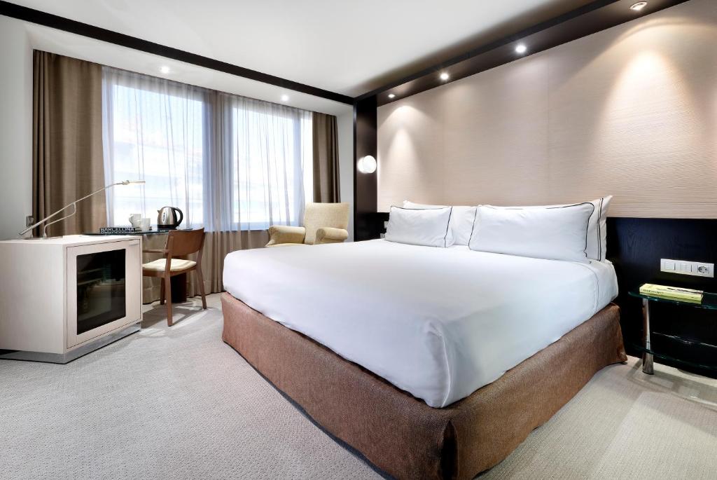 a bedroom with a large bed and a television at Melia Barcelona Sarriá in Barcelona