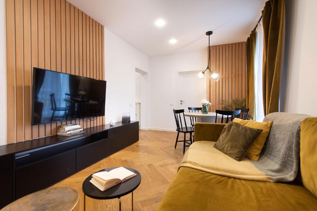 sala de estar con sofá y TV de pantalla plana en Floreasca View by CityLife Suites, en Bucarest