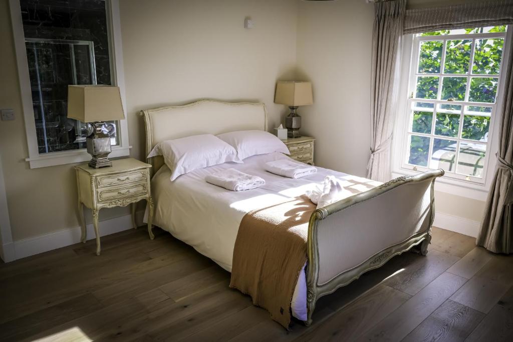 1 dormitorio con 1 cama con 2 mesitas de noche y una ventana en Moulton Lawn House B&B 