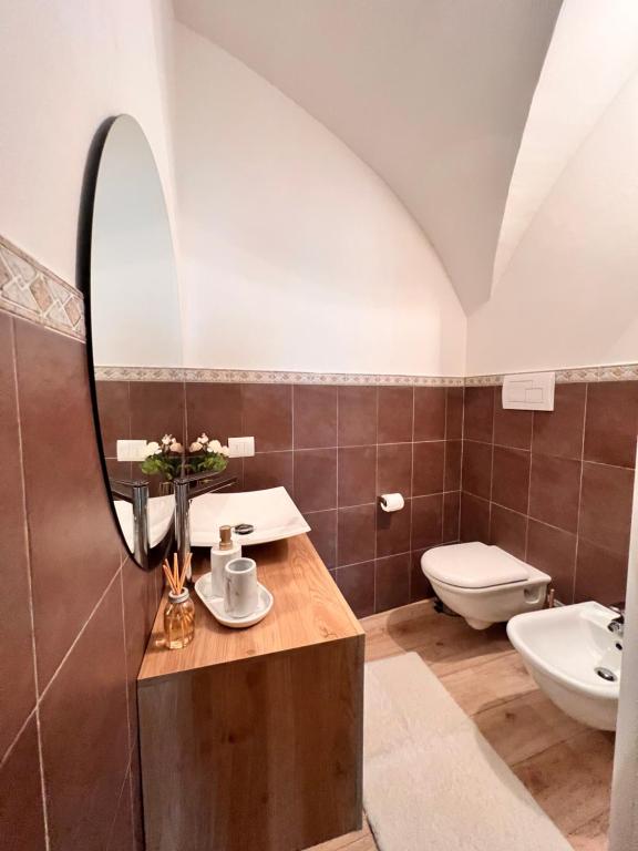 ein Bad mit einem Waschbecken und einem Spiegel in der Unterkunft L’Arco sul Lago • Gold Apartment in Castro