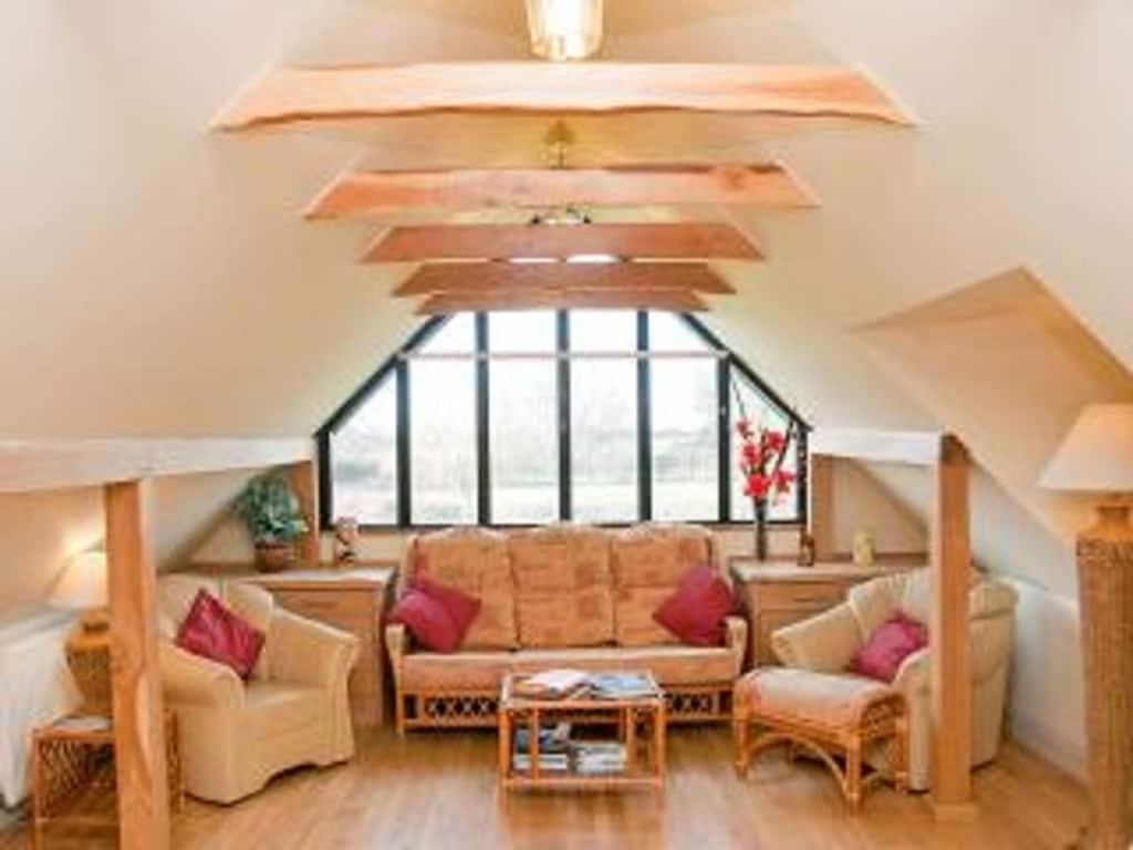 sala de estar con sofá y ventana grande en Owls Nest - Peace and Tranquility near Woodbridge & Framlingham in rural Suffolk en Woodbridge