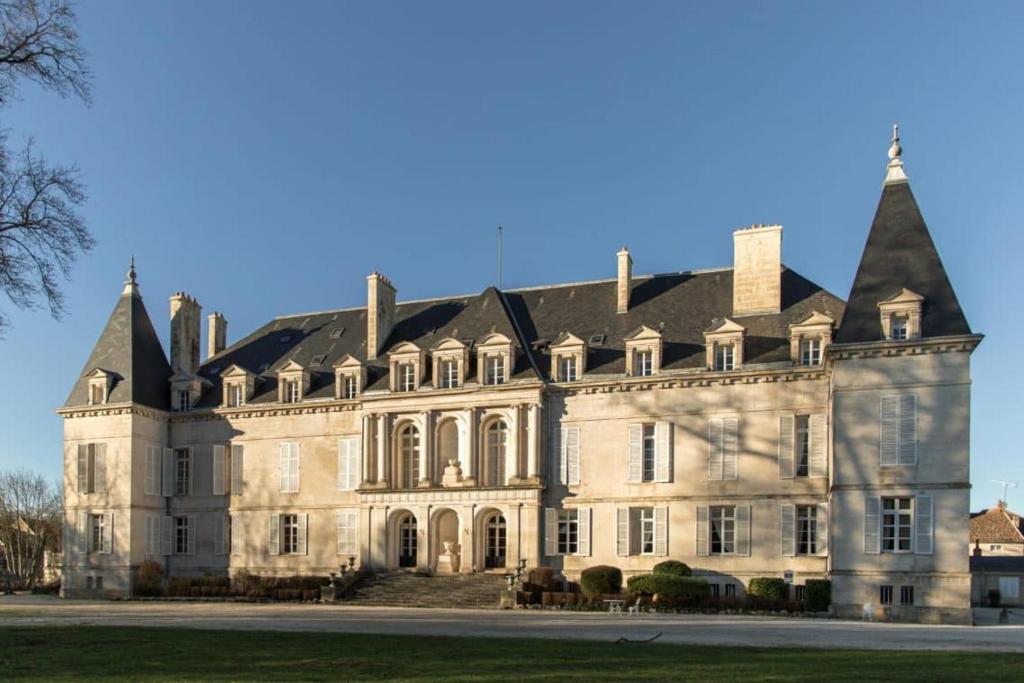 un gran edificio de piedra con techo negro en La Roulotte de Loïs & Clara, en Arc-en-Barrois