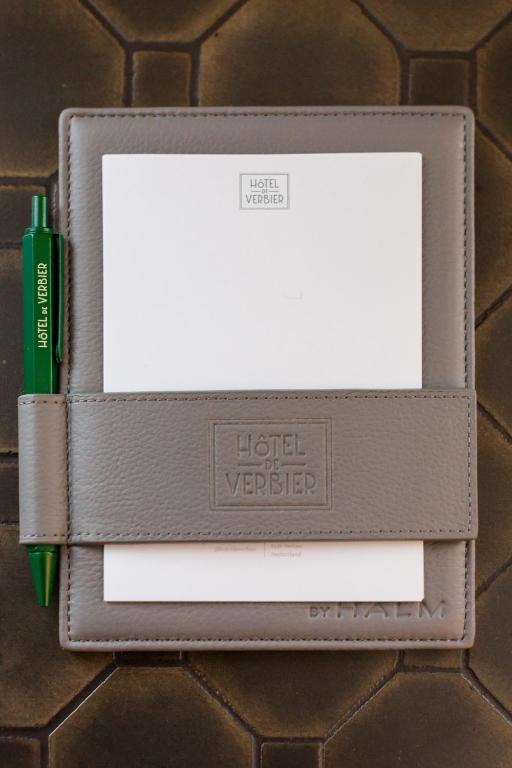 a lighter and a pen in a brown wallet at Hôtel de Verbier SUP in Verbier