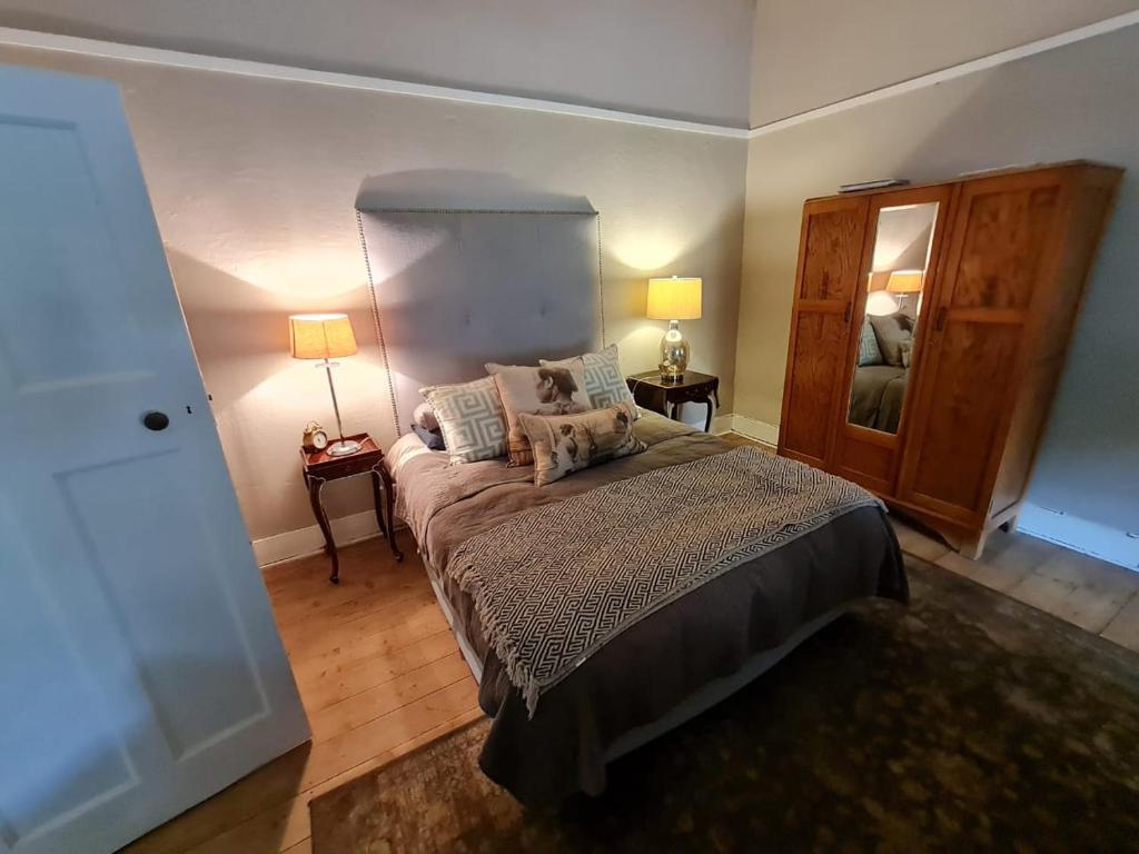- une chambre avec un lit, deux lampes et un miroir dans l'établissement On 17th Voortrekker, à Paul Roux