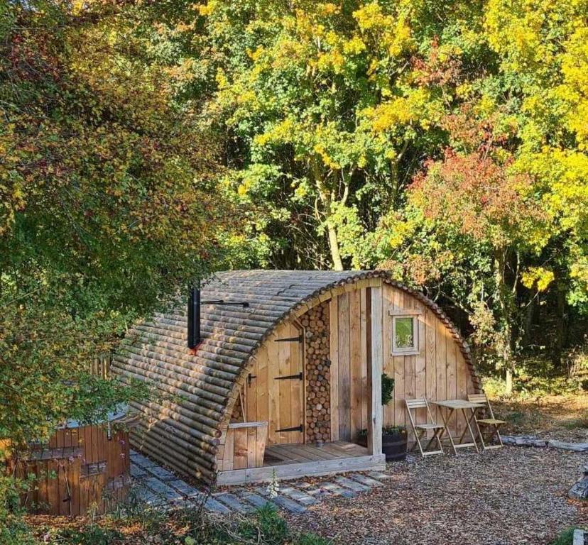une petite cabane en bois avec une table dans une forêt dans l'établissement Fox Lodge at Heygates Lodging - with hot tub, 