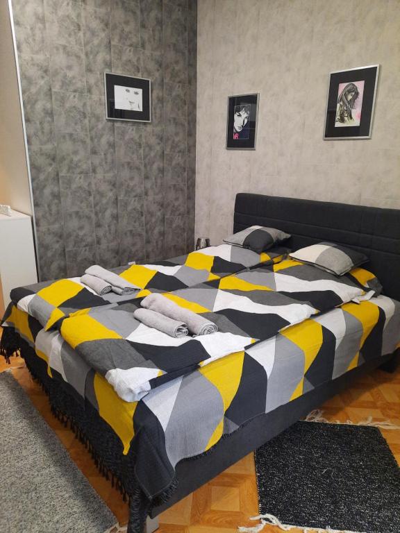 een slaapkamer met een bed met een geel en zwart dekbed bij Apartman STEVAN Vrnjačka Banja in Vrnjačka Banja