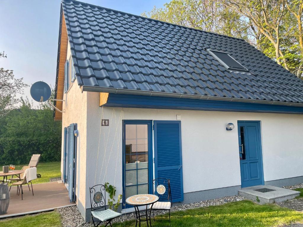 uma pequena casa branca com portas azuis e um pátio em Ferienhaus Biedermann em Wiek auf Rügen