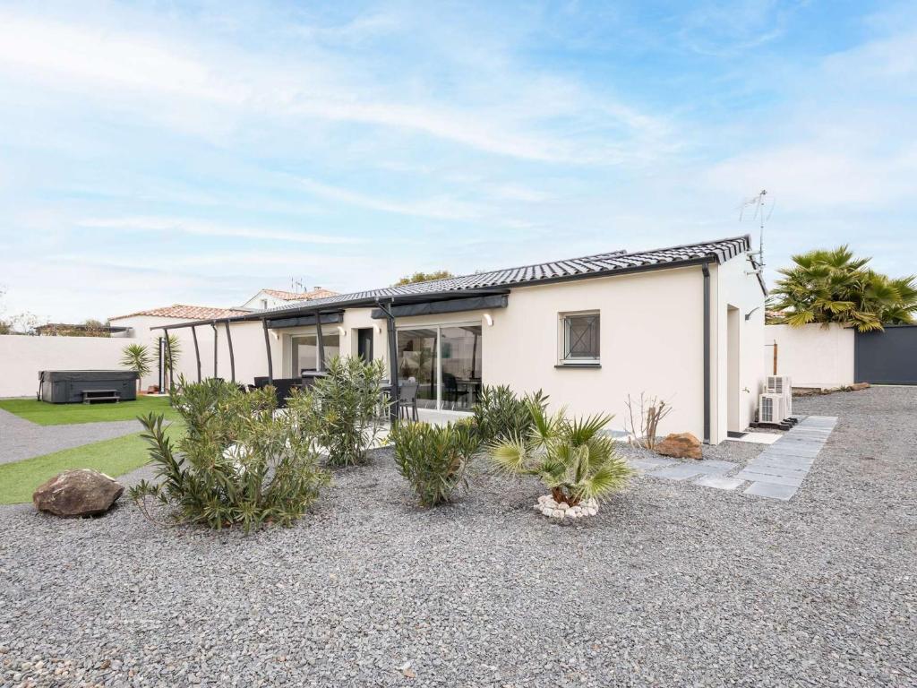 une maison blanche avec des plantes devant dans l'établissement Villa T4 climatisée avec jardin, jacuzzi et Free WiFi à 600 m de la plage - FR-1-423-234, au Cap d'Agde