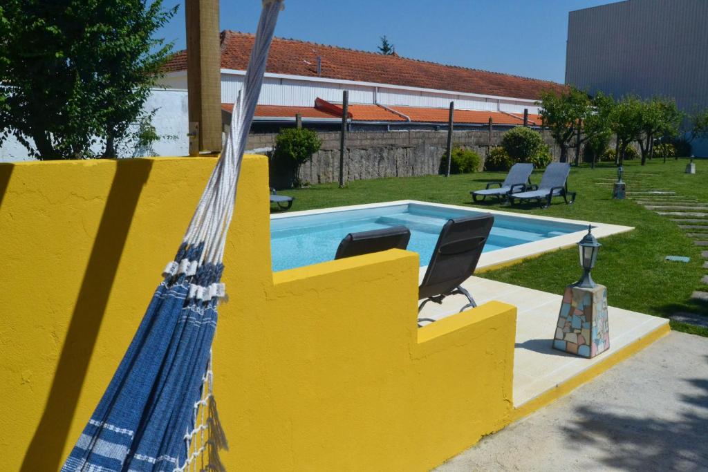 a yellow fence with a swimming pool in a yard at Villa Santa Bárbara in Vila Nova de Gaia
