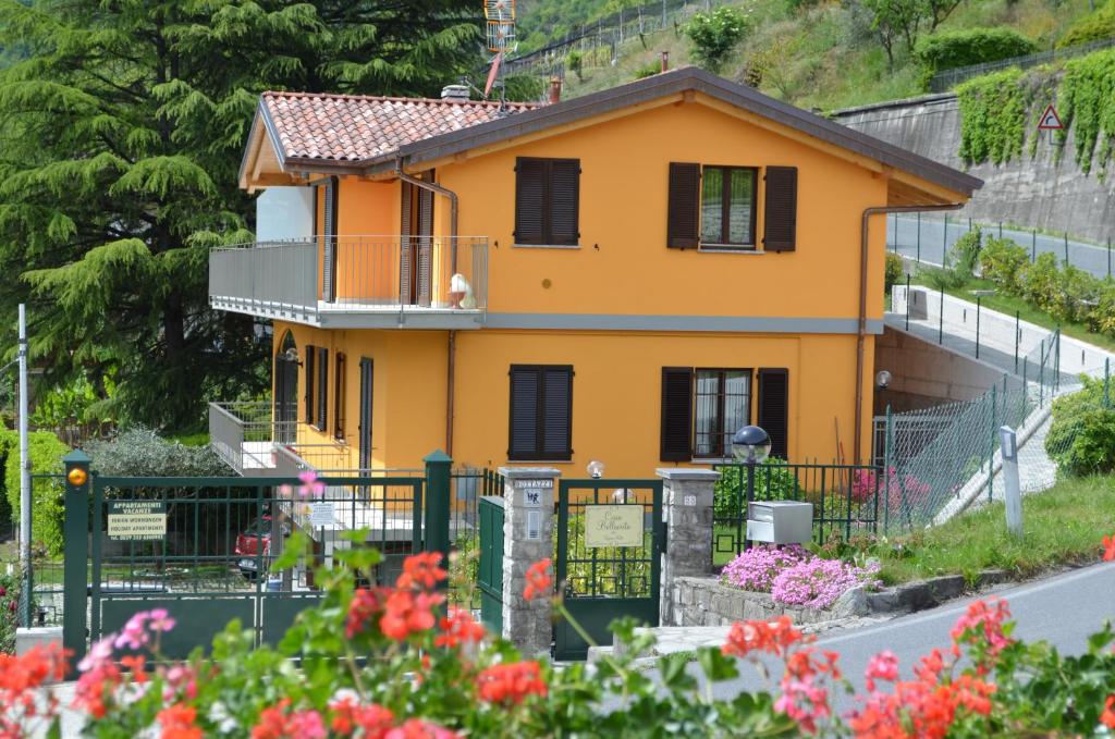 ein gelbes Haus auf einem Hügel mit Blumen in der Unterkunft Casa Bellavista in Porlezza