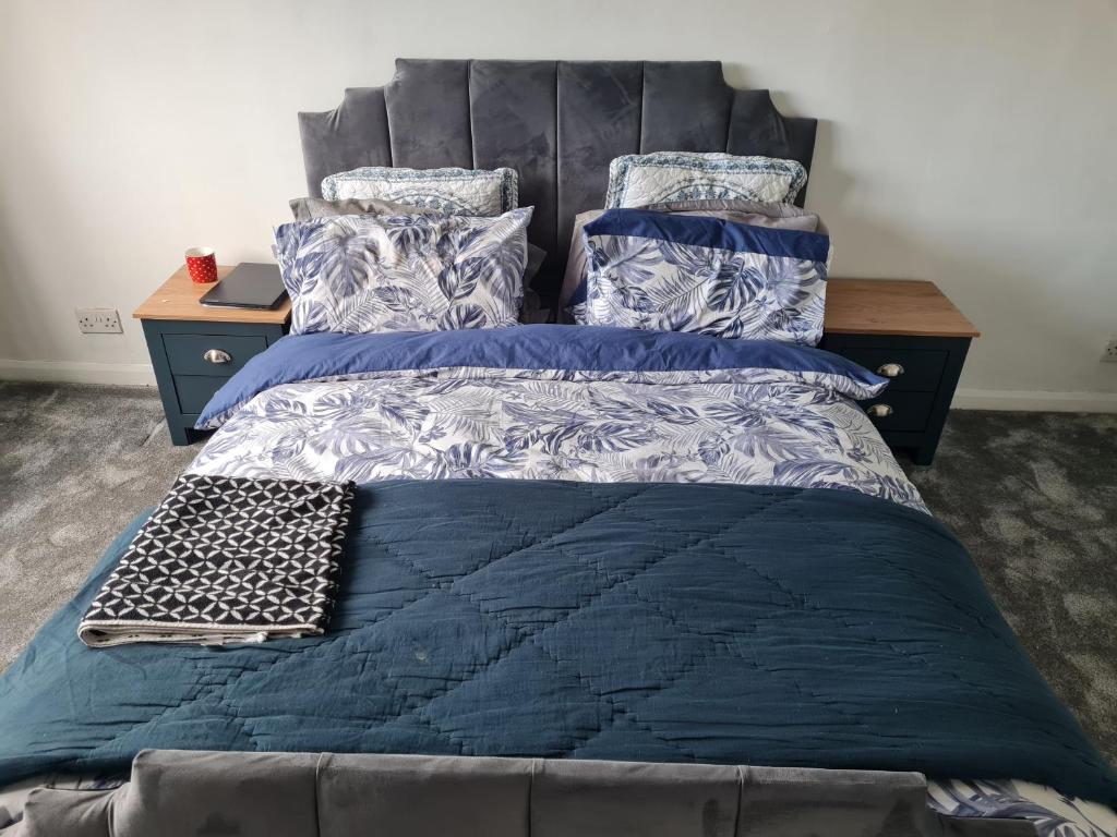 a bedroom with a bed with a blue comforter and pillows at Victoria Road in Erith
