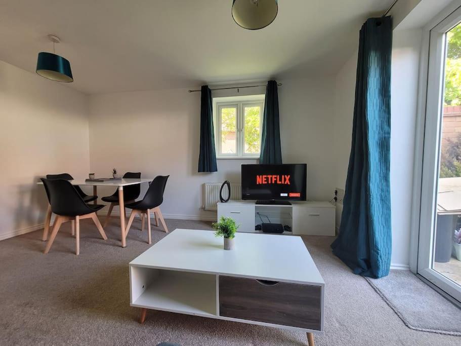 ein Wohnzimmer mit Fernseher und Tisch mit Stühlen in der Unterkunft Kensington House- The Perfect home for contractor stays in Colchester