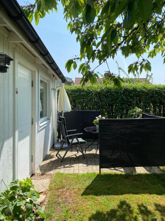eine Terrasse mit einem Stuhl und einem Sonnenschirm in der Unterkunft Liten ”stuga” in Falkenberg