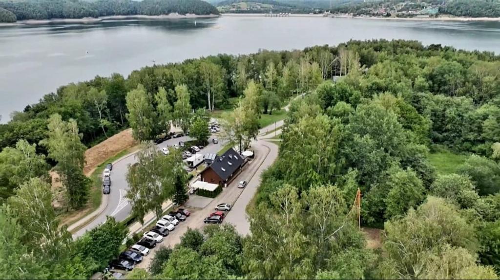 uma vista aérea de um parque de estacionamento ao lado de um lago em Leśne Klimaty em Polańczyk