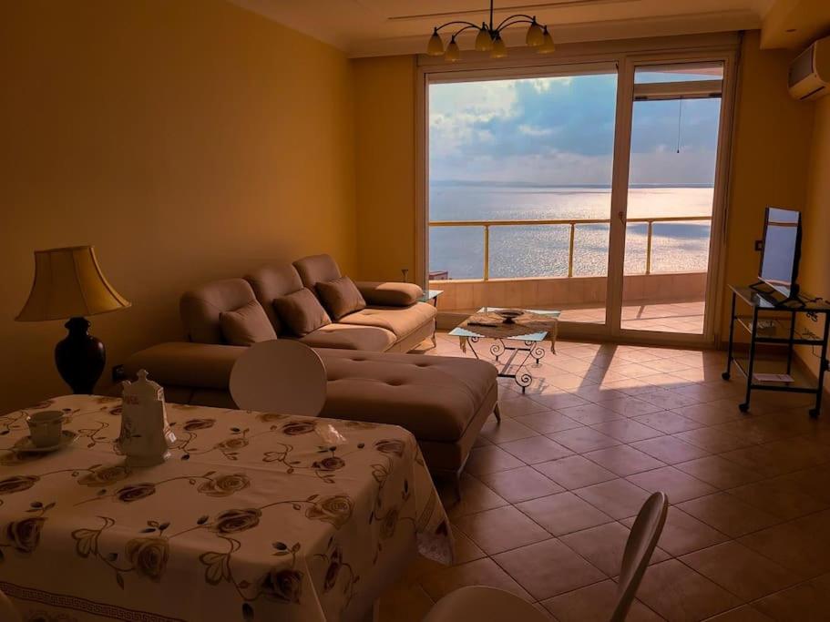 sala de estar con sofá y vistas al océano en Saranda’s Sky Line Apartment, en Sarandë