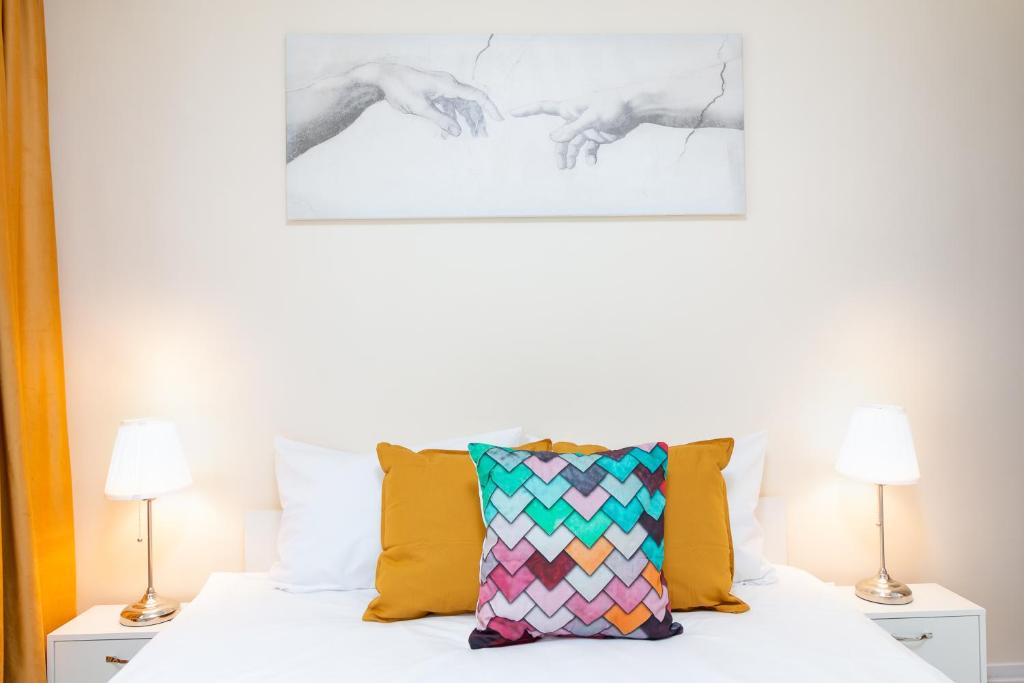 Dormitorio con cama blanca y almohada colorida en Sovata Studio, en Oradea