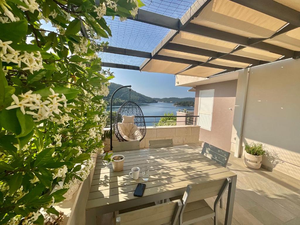 eine Terrasse mit einem Tisch und Stühlen auf dem Balkon in der Unterkunft Villa Iva Lastovo in Ubli