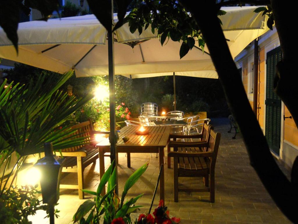 ein Tisch und Stühle unter einem Sonnenschirm auf einer Terrasse in der Unterkunft Locanda Villa Moderna in Genua