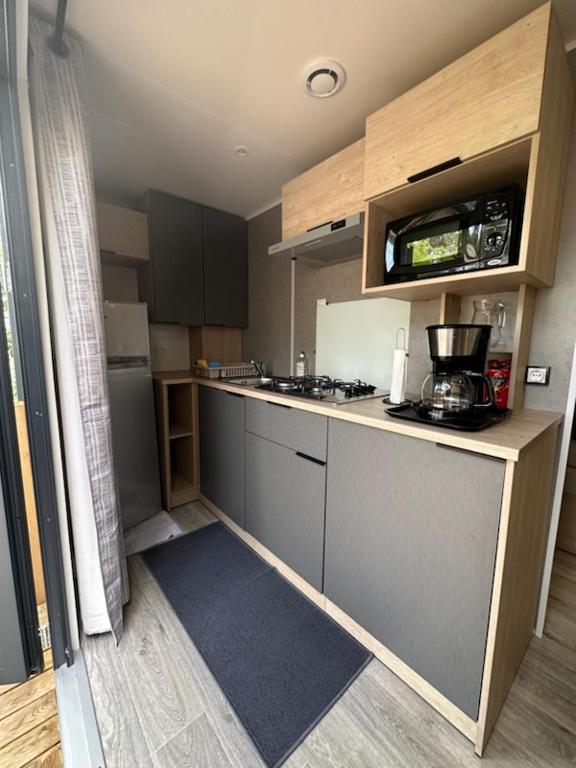 - une petite cuisine avec un comptoir et un comptoir dans l'établissement Mobil-home, à Lit-et-Mixe