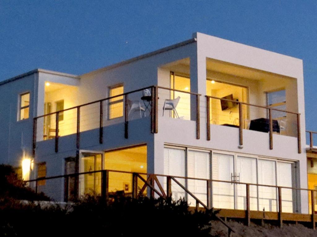 a large white house with a balcony at night at Velddrif River and Sea in Velddrif