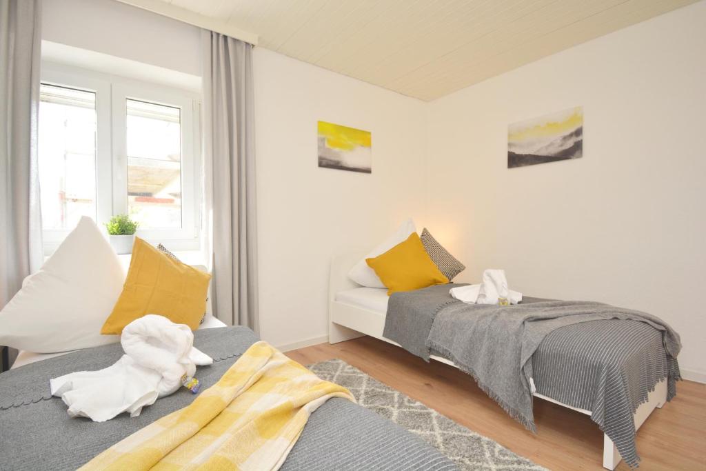 a bedroom with two beds with yellow and white pillows at FO02-RI Apartment für Facharbeiter in Forchheim in Forchheim