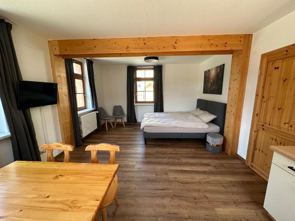 uma sala de estar com uma cama e uma mesa em Ferienhaus "Kleines Domizil" Altenberg - direkt im Zentrum von Altenberg gegenüber vom Skilift em Kurort Altenberg