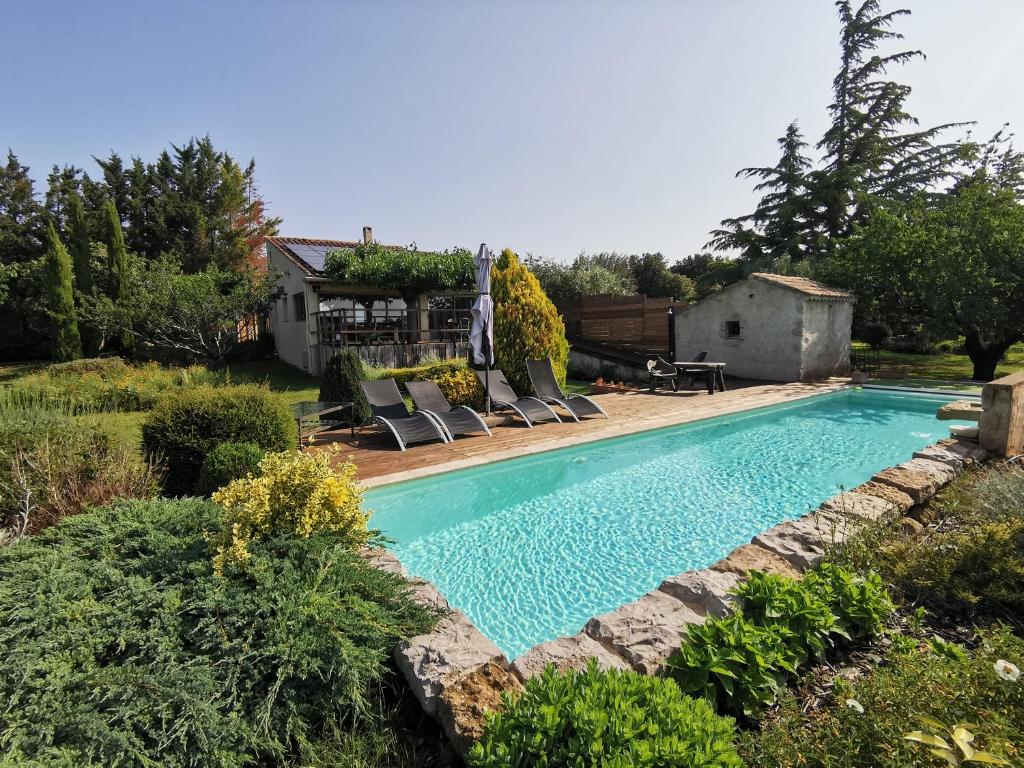a swimming pool in a yard with chairs and a house at Gîte la Saume in Lambesc