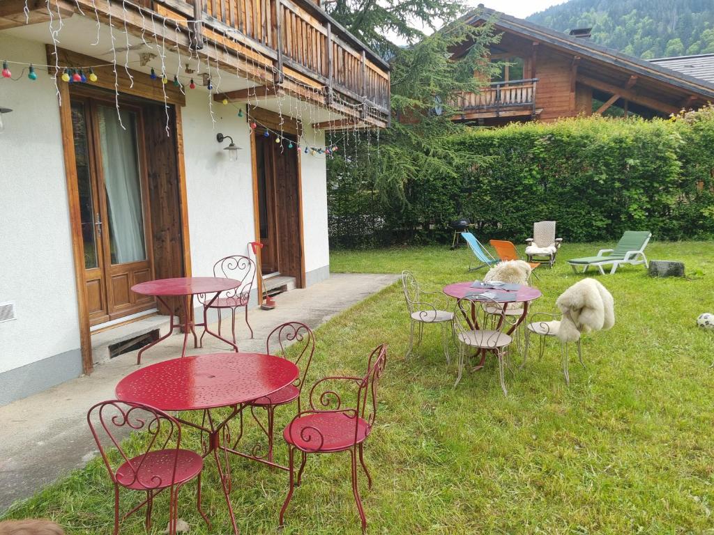a group of tables and chairs in a yard at Le Petit Poucet Appartement rez-de-chaussée avec grand jardin in Morzine