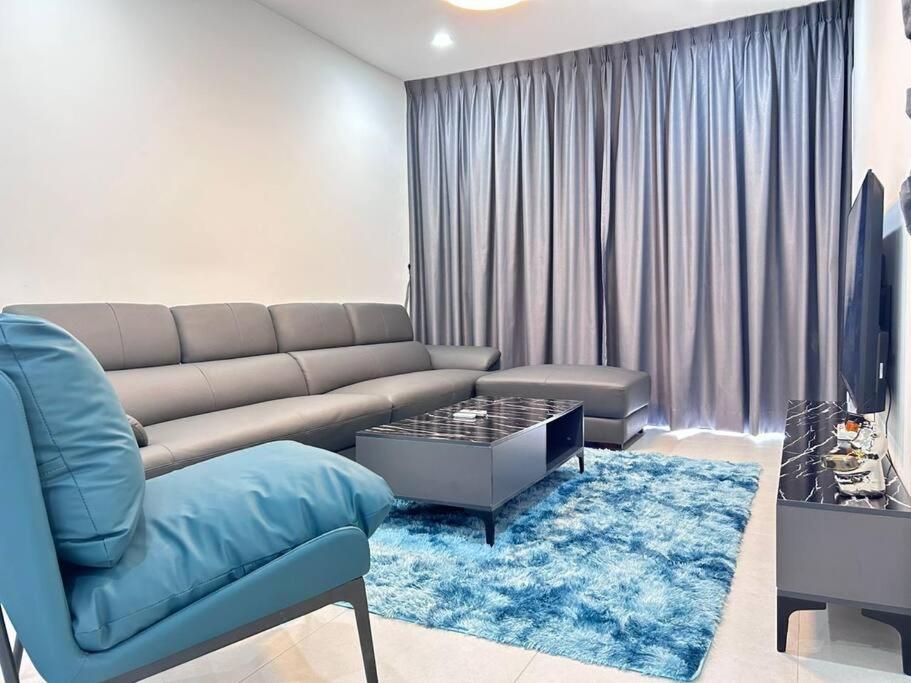 een woonkamer met een bank en een blauw tapijt bij Jeff & Ricky Homestay 77@ Armadale Residence in Kuching