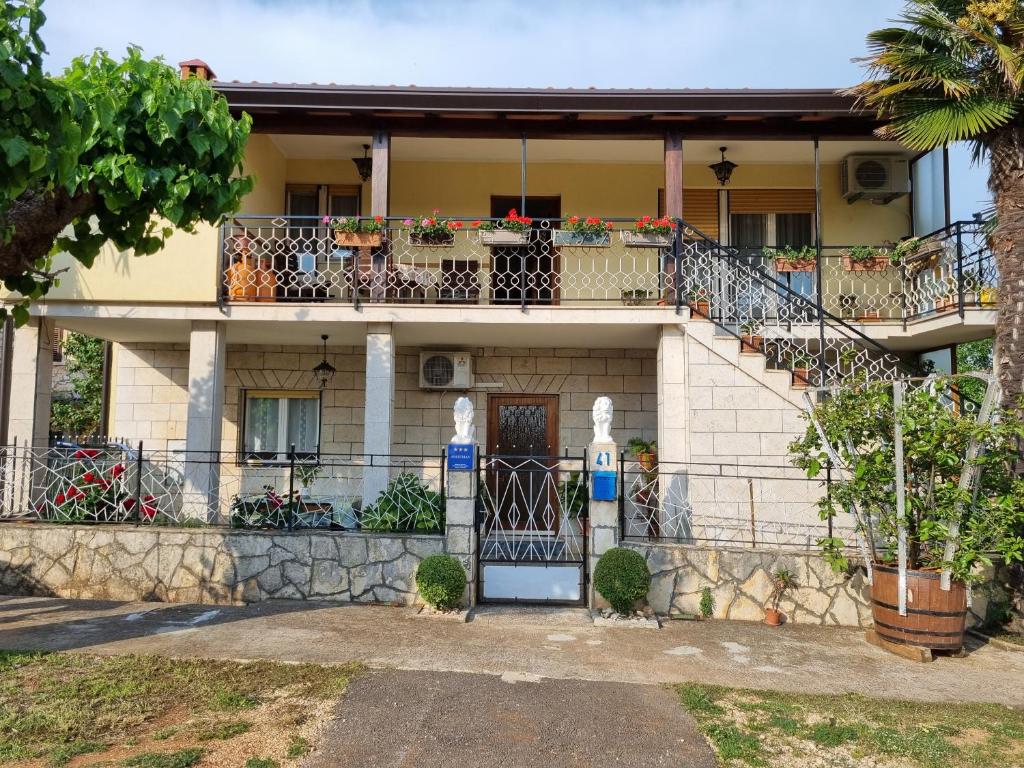 a house with a balcony and a gate at Apartment Felice in Novigrad Istria