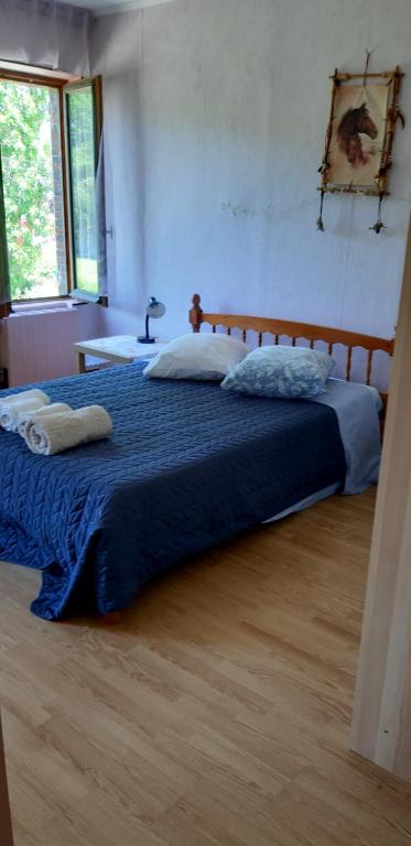 une chambre avec un grand lit avec une couverture bleue dans l'établissement Chez Josie, chambre 18mCarre dans une longère Normande, à Francheville