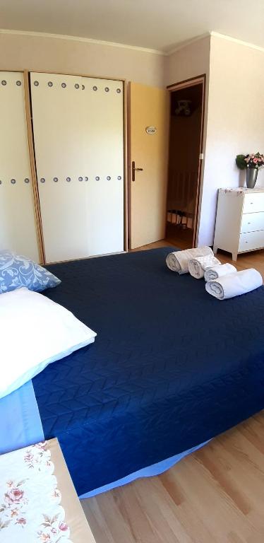 a bedroom with a large blue bed with towels on it at Chez Josie, chambre 18mCarre dans une longère Normande in Francheville