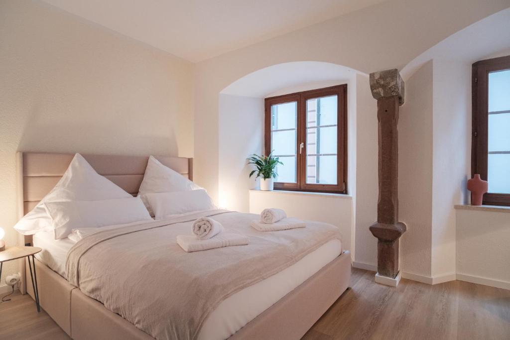- une chambre avec un grand lit blanc et des serviettes dans l'établissement Neues Design-Apartment, Altstadt, Business&Ferien, Küche, Netflix, à Bad Säckingen