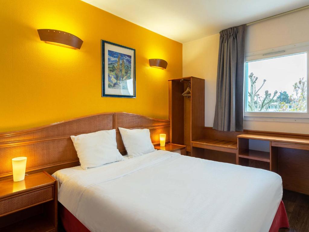 een slaapkamer met een groot bed en een raam bij B&B HOTEL Strasbourg Nord Mundolsheim in Mundolsheim