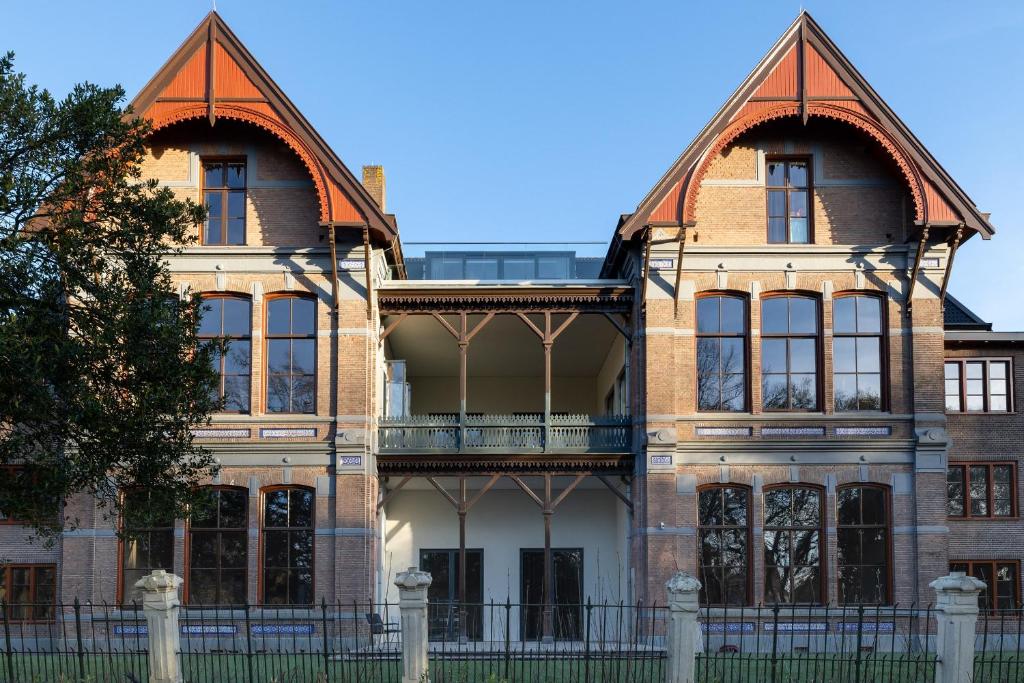 un antiguo edificio de ladrillo con grandes ventanas en Park Lofts Groningen apartment 4, en Groninga