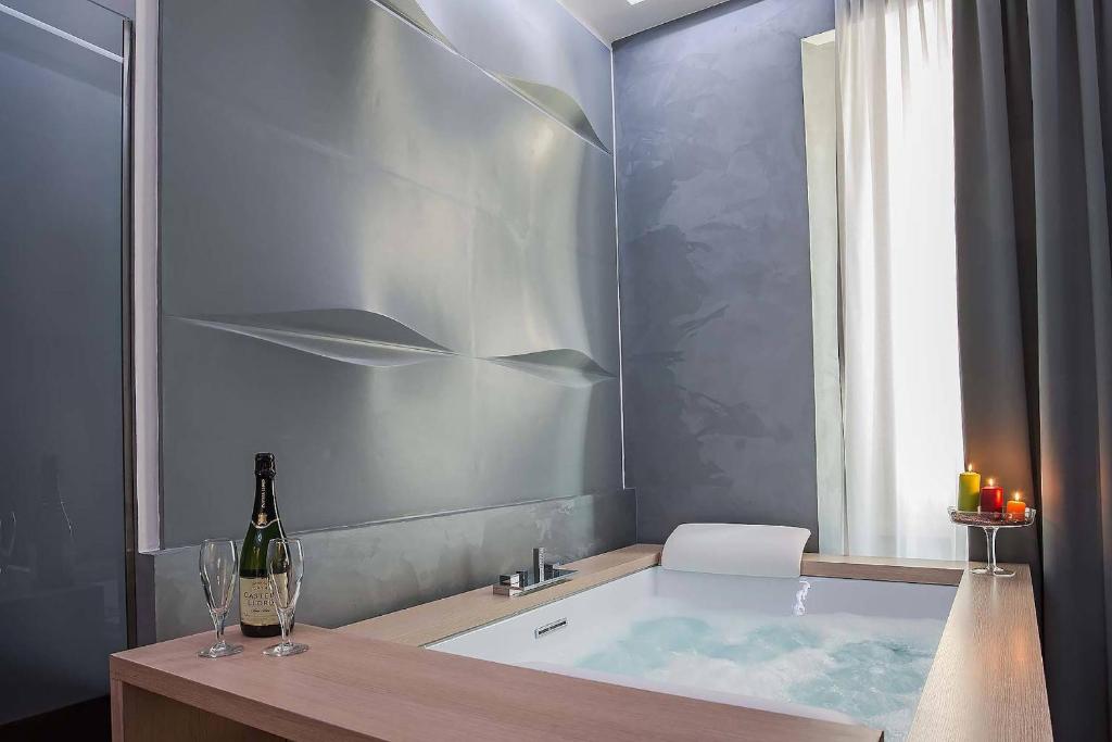 uma casa de banho com uma banheira e uma garrafa de vinho em 7 Inn Spanish Steps em Roma