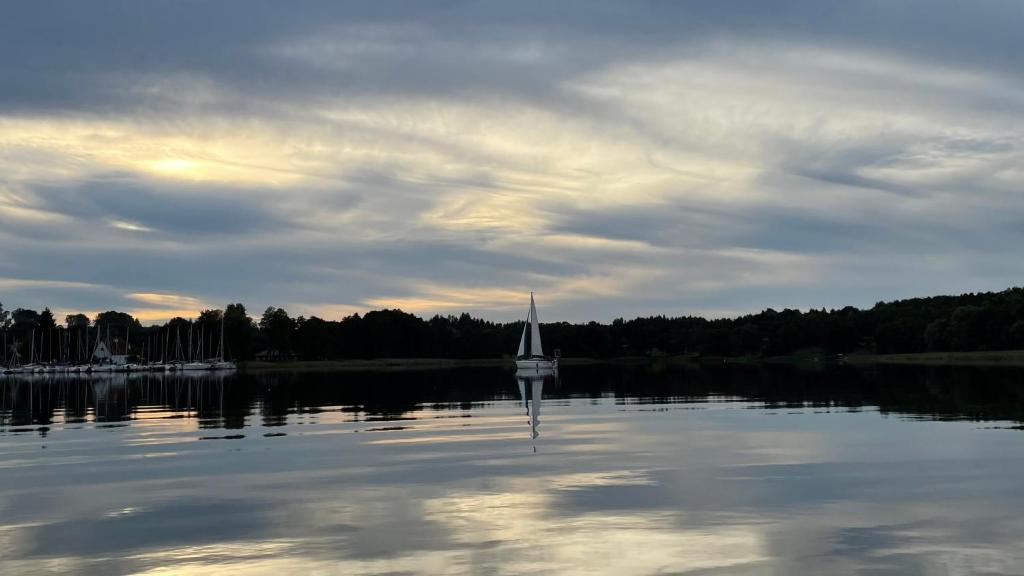 a sail boat in the water on a lake at Dom wakacyjny Bogaczewo in Bogaczewo