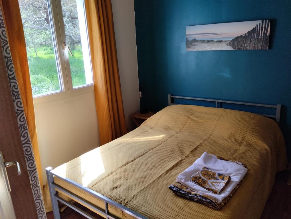 a bed in a blue room with a window at maisonnette proche gare et plages in Arcachon