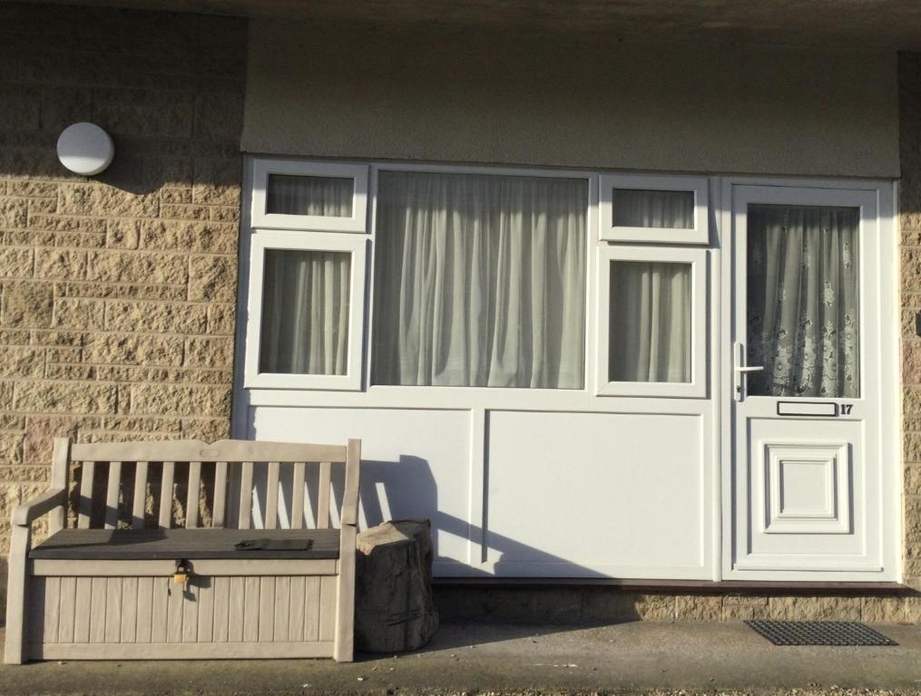 a building with two windows and a bench in front of it at Hillview in Brean