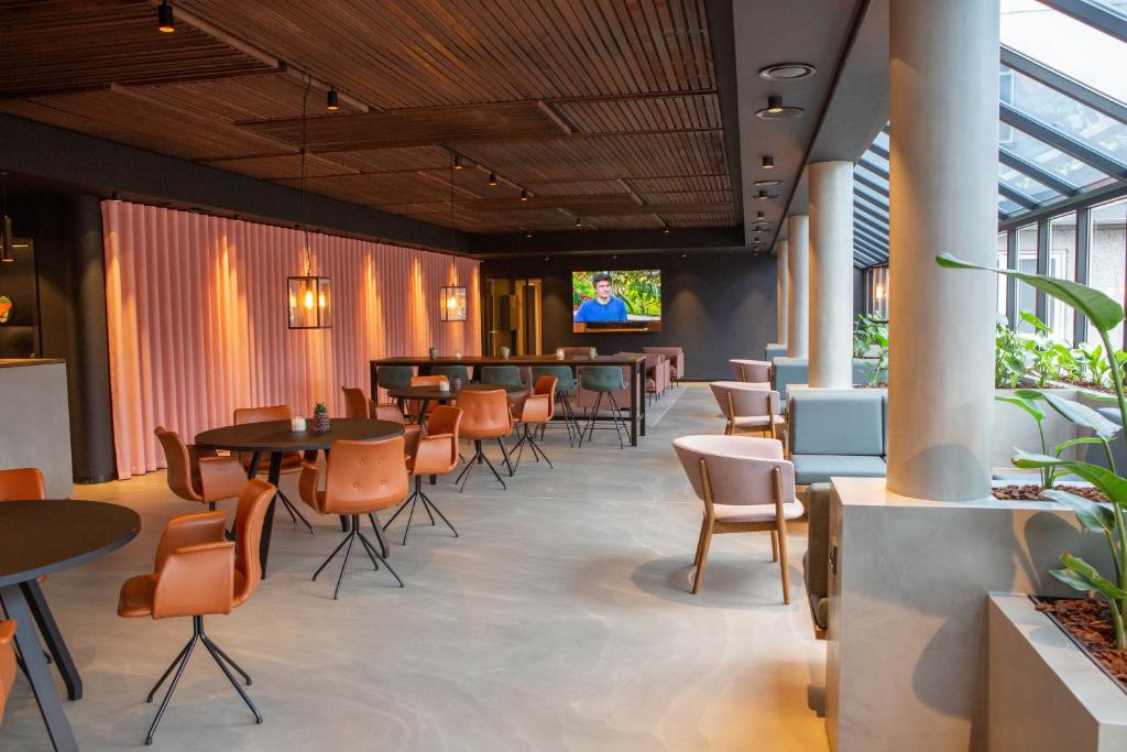 un ristorante con tavoli e sedie e un bar di Struer Grand Hotel a Struer