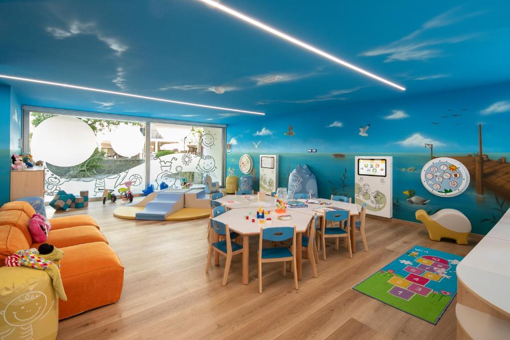 - une salle de jeux pour enfants avec une table et des chaises dans l'établissement Residence Serenissima, à Bibione