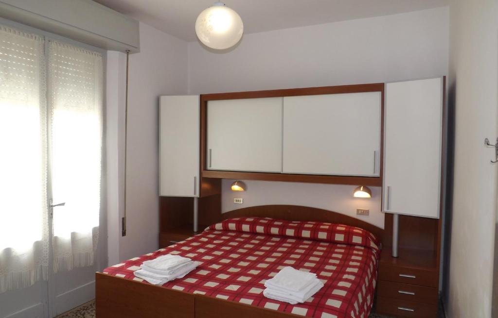 a bedroom with a red and white bed and a window at Hotel La Vela in Bellaria-Igea Marina
