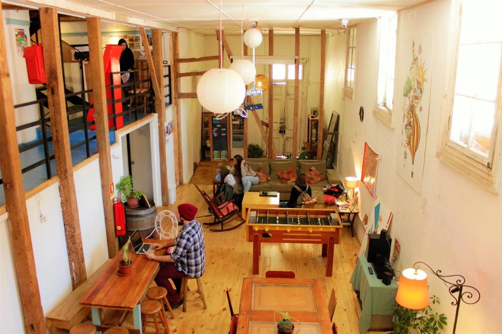 a man sitting at a table in a living room at Casa Volante Hostal in Valparaíso