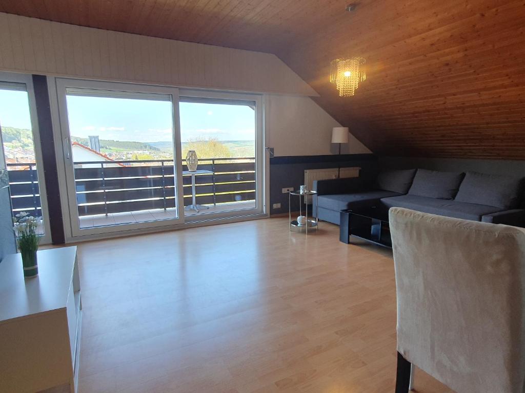 a living room with a couch and a large window at Wohnung mit Ausblick in Tauberbischofsheim in Tauberbischofsheim