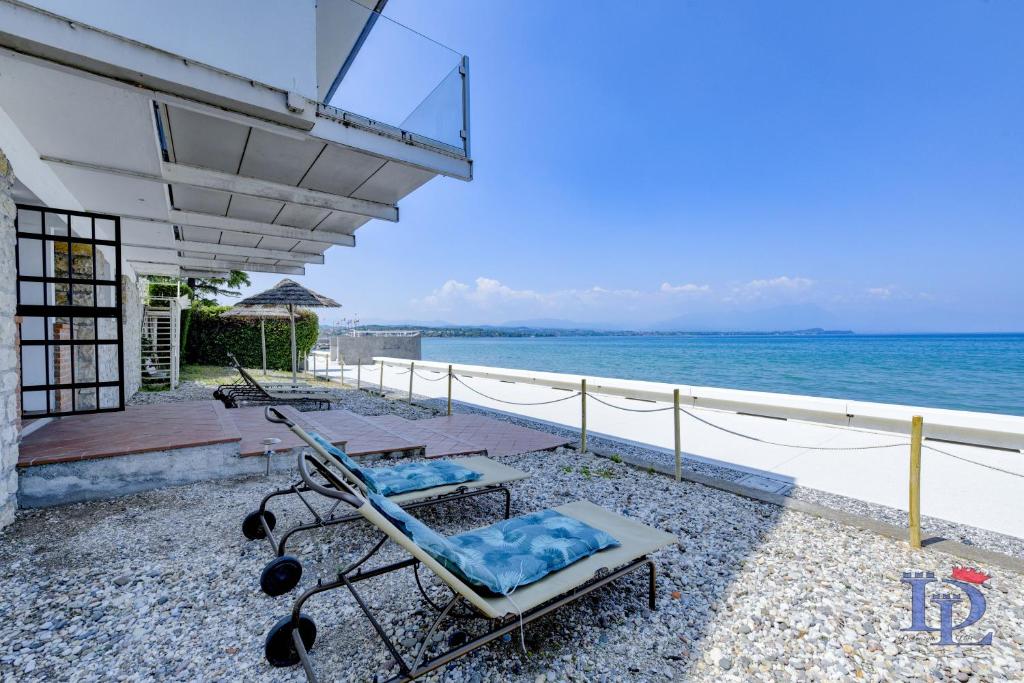 a couple of lounge chairs sitting on top of a beach at DesenzanoLoft Villa Meraviglia in Desenzano del Garda