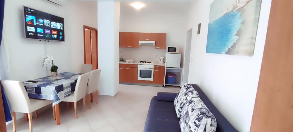 a living room with a dining room table and a kitchen at Apartments Burazer in Šibenik