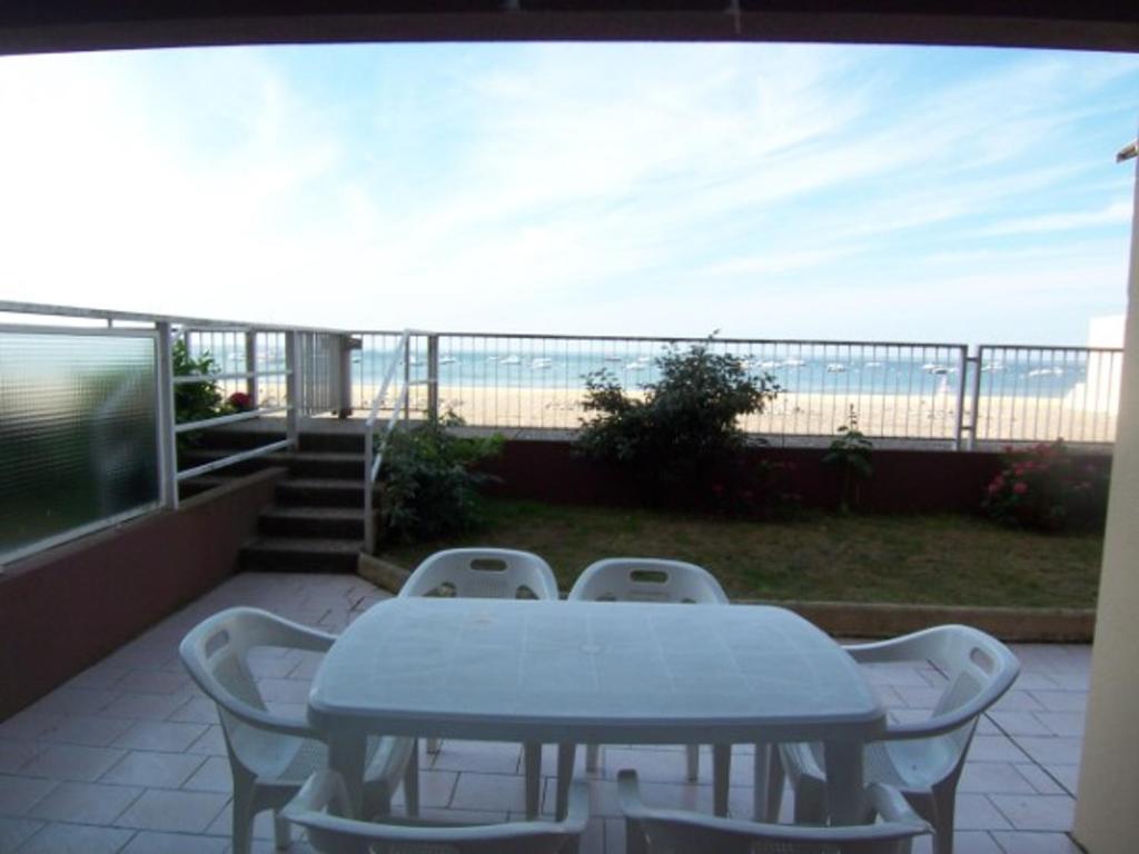 une table et des chaises sur un balcon avec la plage dans l'établissement Appartement T2 avec terrasse et parking à Arcachon - FR-1-374-78, à Arcachon